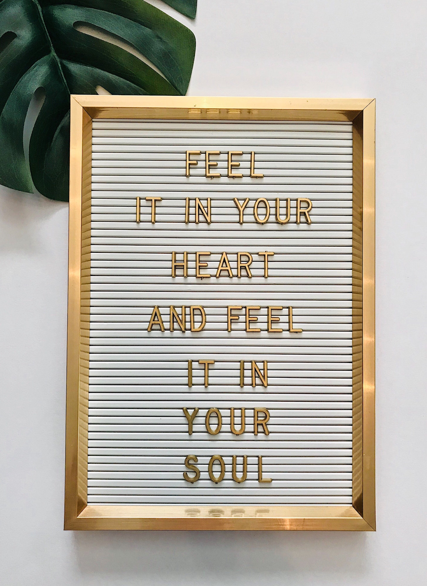 „Feel it in your heart and feel it in your soul“ on letter board / gold concept