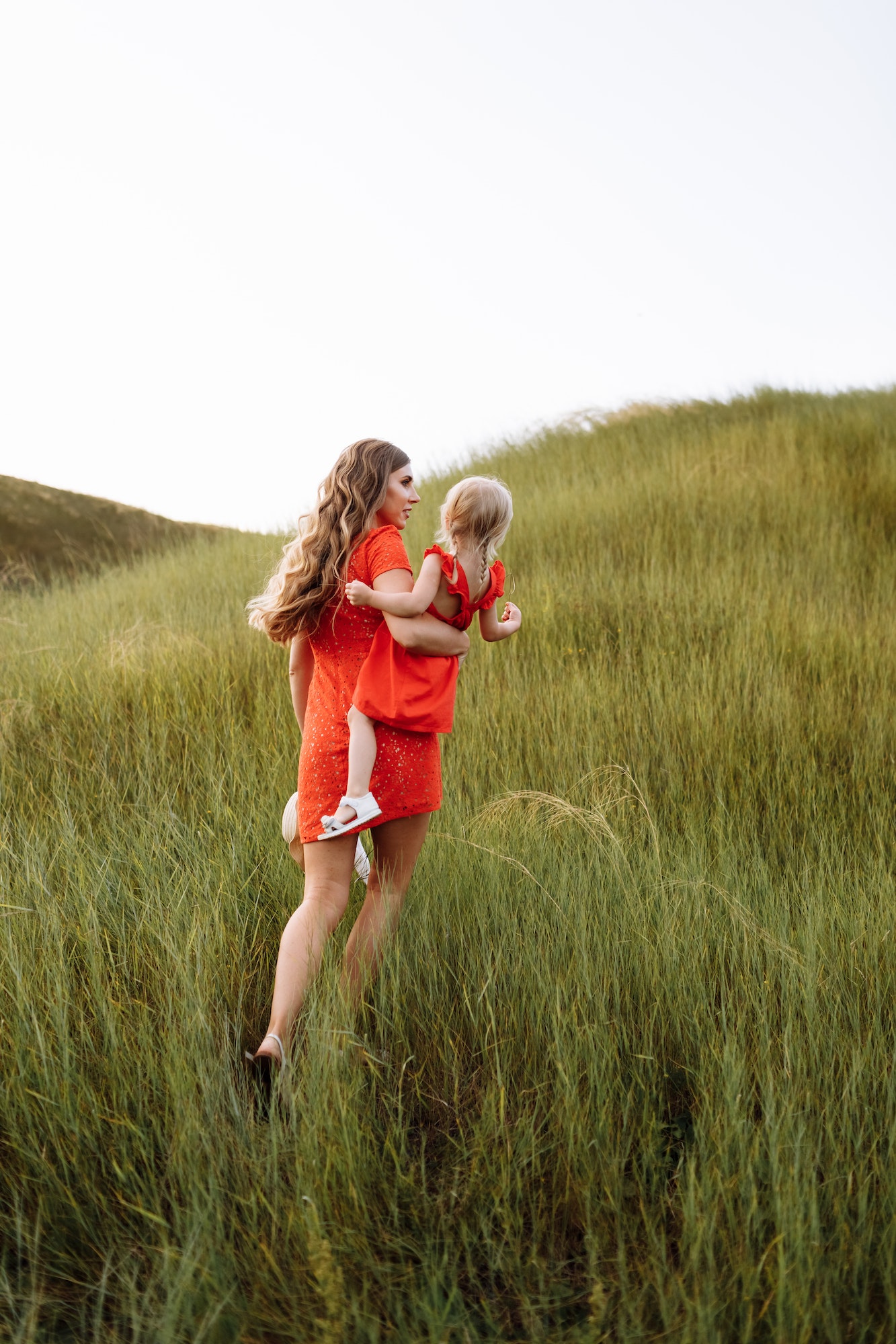 young beautiful mother and little daughter walking on nature on summer day vacation. Mom and